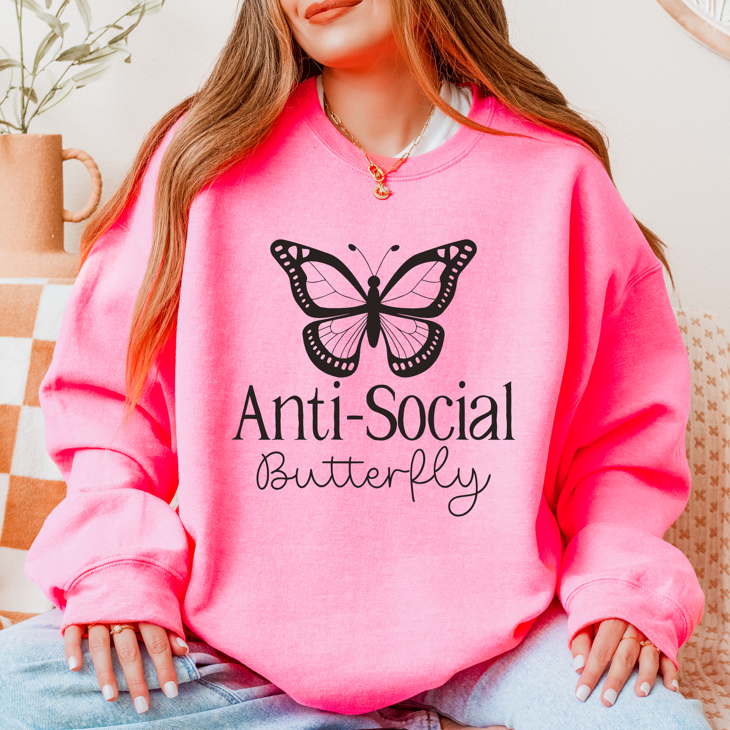 Bright Pink sweatshirt that has a butterfly and the words anti sovisocial butterfly in black