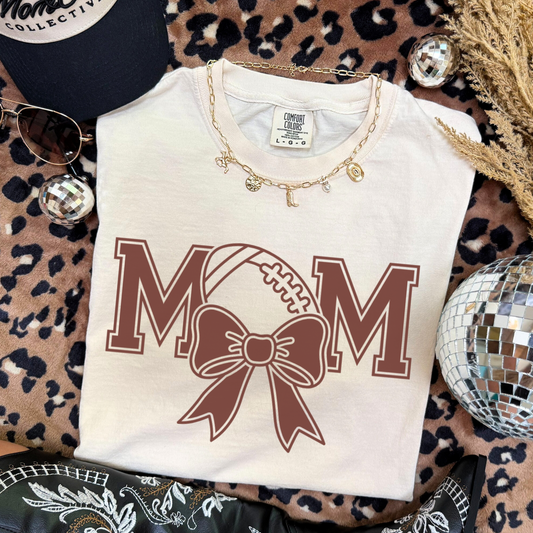 White t-shirt with 'MOM' design. The 'O' is a football