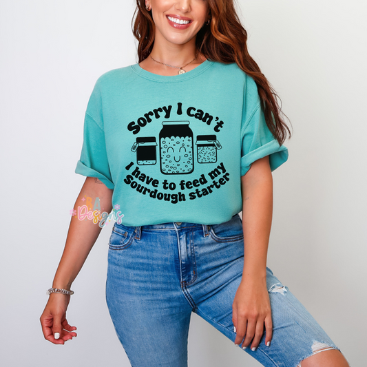 blue shirt that says "sorry I cant I have to feed my sourdough starter" in black