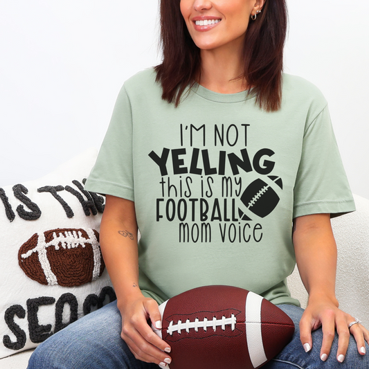 Woman wearing a t-shirt with a humorous football-themed message, holding a football.