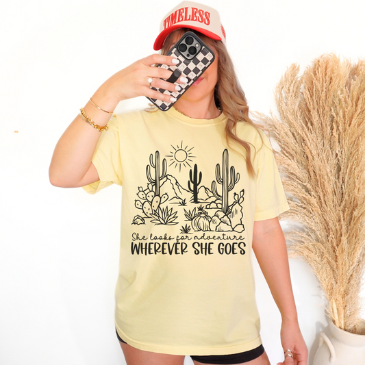 Light yellow shirt with "She Looks for adventures wherever she goes" on the front.