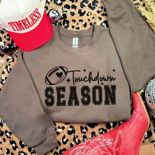 Gray sweatshirt with 'Touchdown Season' text, red cowboy boot, and leopard print surface