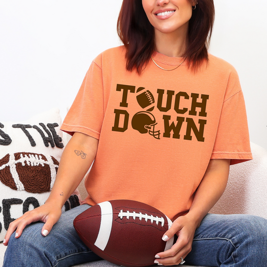 Person wearing an orange 'Touchdown' t-shirt holding a football.
