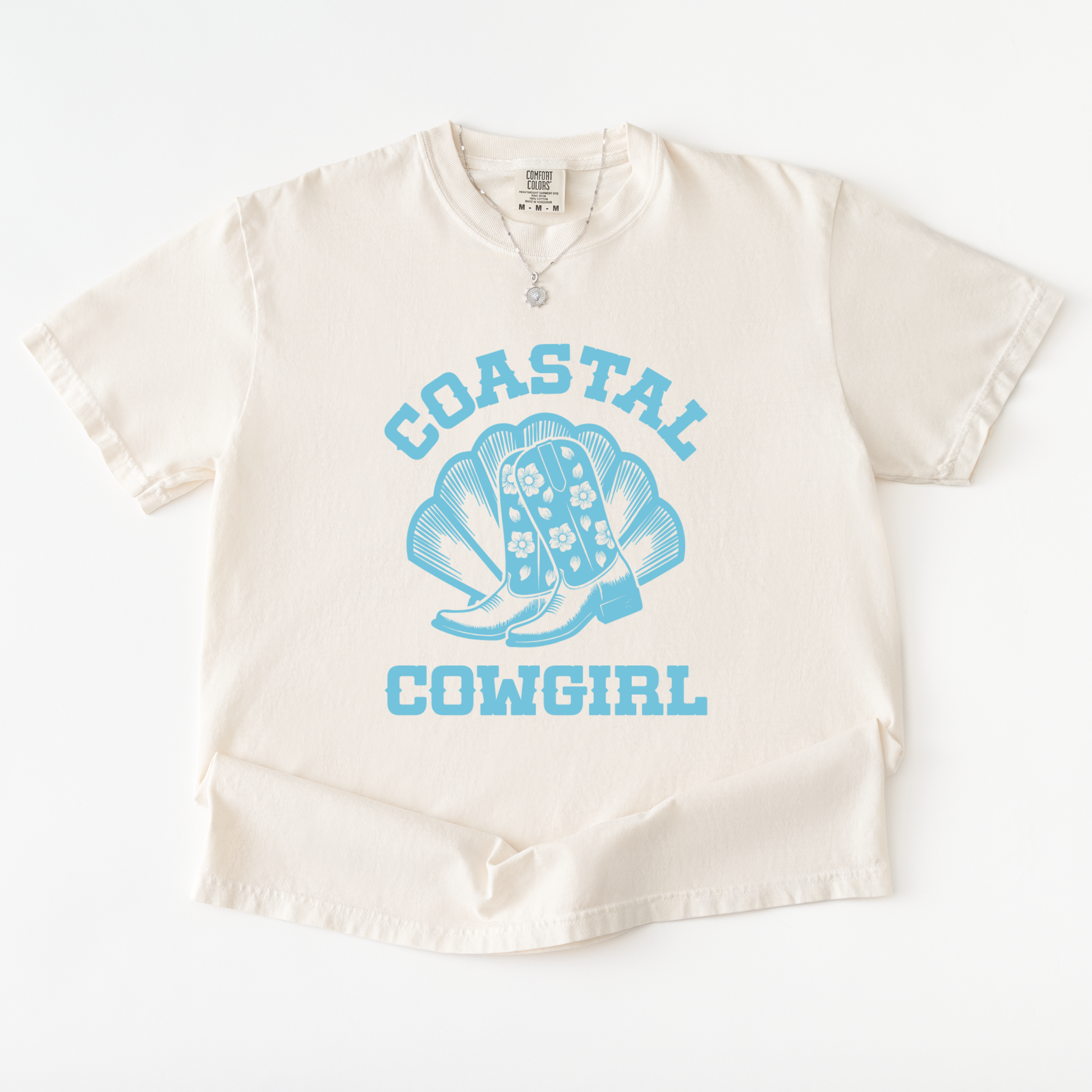 Beige baby romper with blue 'Coastal Cowgirl' text and boot design on a white background