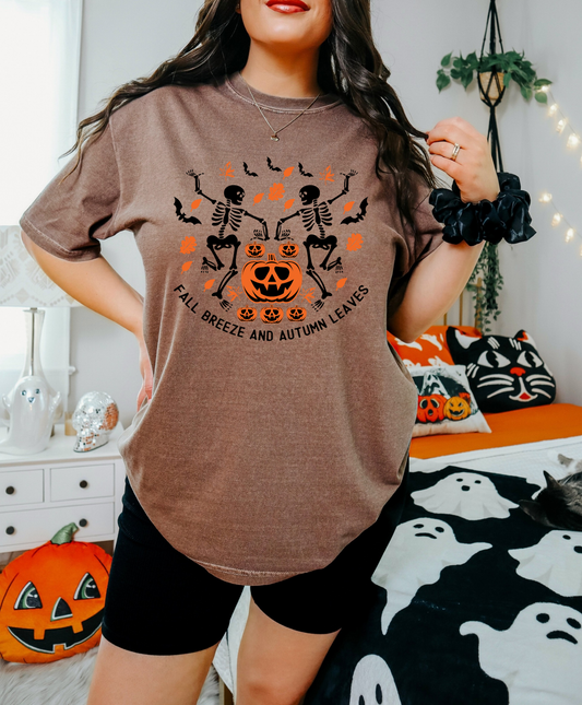 Person wearing a brown t-shirt with Halloween-themed design in a decorated room.