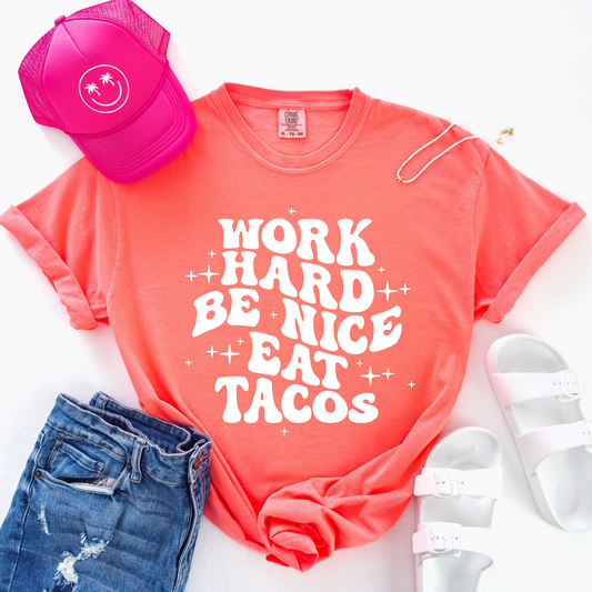 neon red orange shirt that has "work hard, be nice, eat tacos" in a white retro wavy font